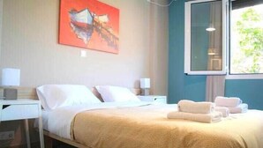 A hotel room with a bed, two bedside tables, a nightstand, a window, and a painting on the wall. - Chic and Minimal apartment close to Thissio Metro (Athina)