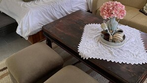 A bedroom with a bed, a bedside table with a vase of flowers, and a chair. - TRADITIONAL VILLA ,COZY LITTLE HOUSE FOR A FAMILY, FOR FRIENDS OR COUPLES... (ΤΡΙΚΑΛΑ)