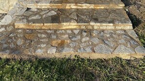 A stone staircase leading to a gated entrance of a house with a door and a window. - TRADITIONAL VILLA ,COZY LITTLE HOUSE FOR A FAMILY, FOR FRIENDS OR COUPLES... (ΤΡΙΚΑΛΑ)