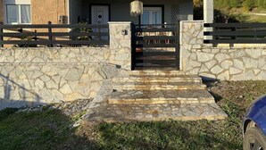 A two-story house with a stone facade, a front porch, and a wooden fence. - TRADITIONAL VILLA ,COZY LITTLE HOUSE FOR A FAMILY, FOR FRIENDS OR COUPLES... (ΤΡΙΚΑΛΑ)