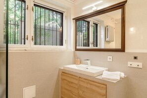 A bathroom with a large window, a sink, a mirror, and a towel. - Wawer Juhasów (Warsaw)