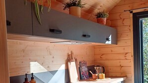 Una cocina moderna con armarios de madera, lavavajillas integrado y ventana que proporciona luz natural.
