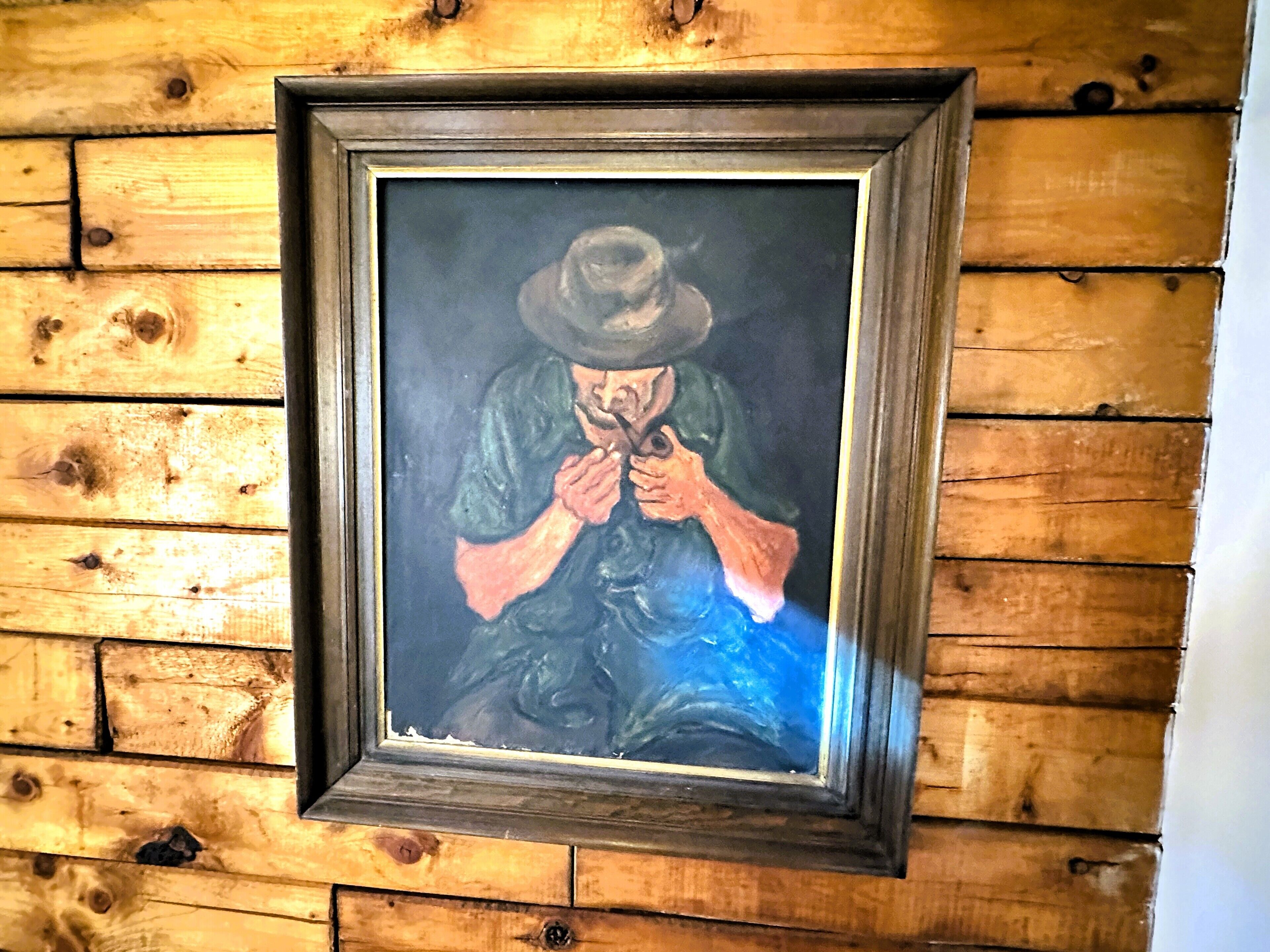 A framed artwork on a wooden wall.