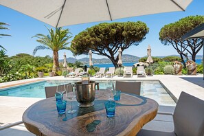 Relax by the pool surrounded by lush greenery and scenic ocean views.