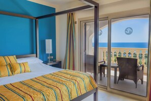 A hotel room with a bed, a nightstand, a chair, and a balcony with a view of the sea. - Villa Treya - Star property, stunning views (San Jaime Mediterráneo)