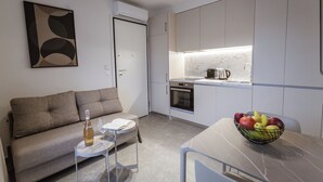 Ett modernt kök med vita skåp, en inbyggd ugn och en matplats med ett bord och stolar.