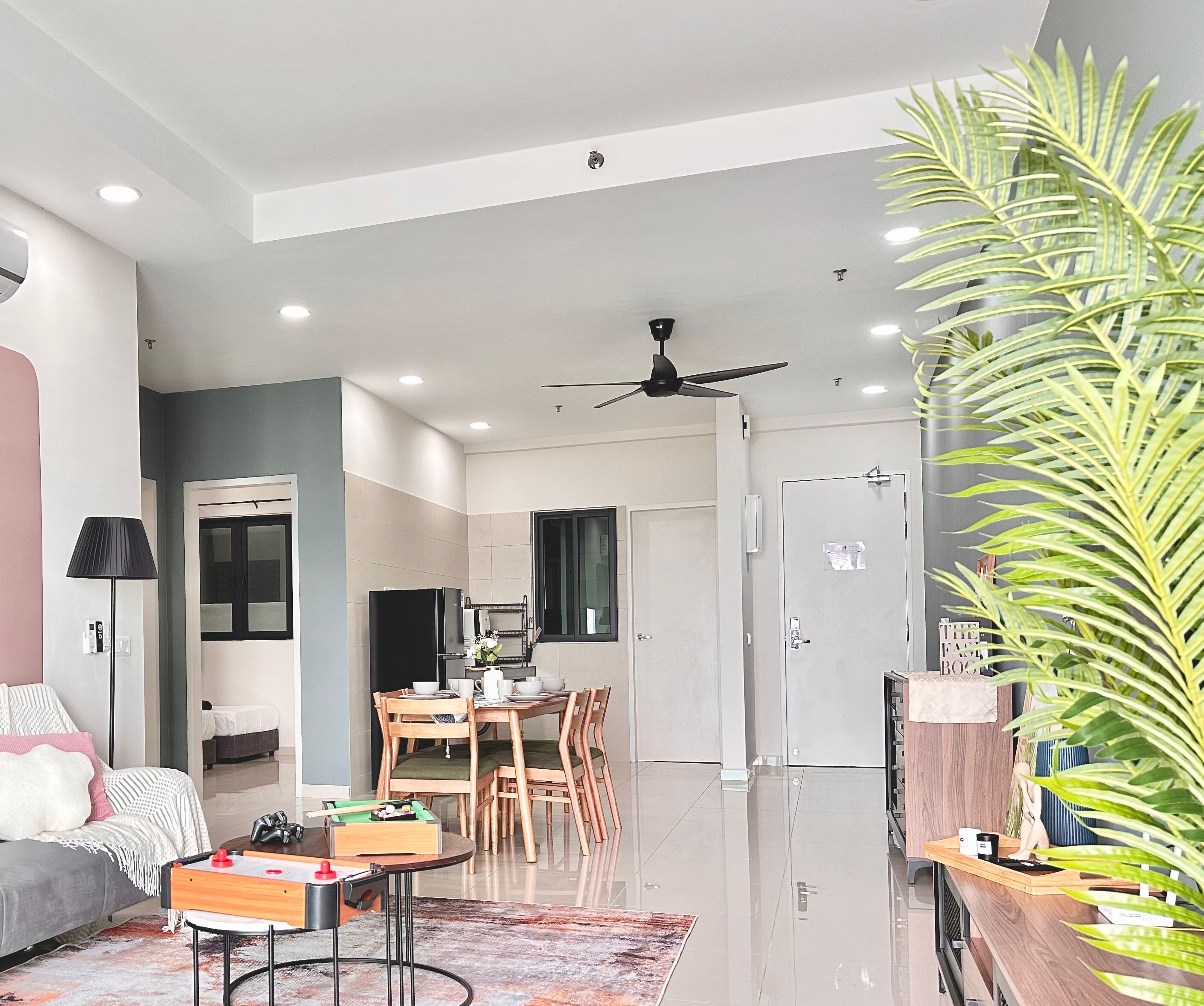 A modern living room with a sofa, a coffee table, and a dining area with chairs and a table.