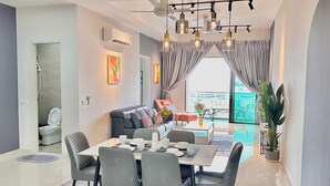 A modern living room with a dining area, a sofa, and a view of the city. - Ong Kim Wee Residence (Malacca City)