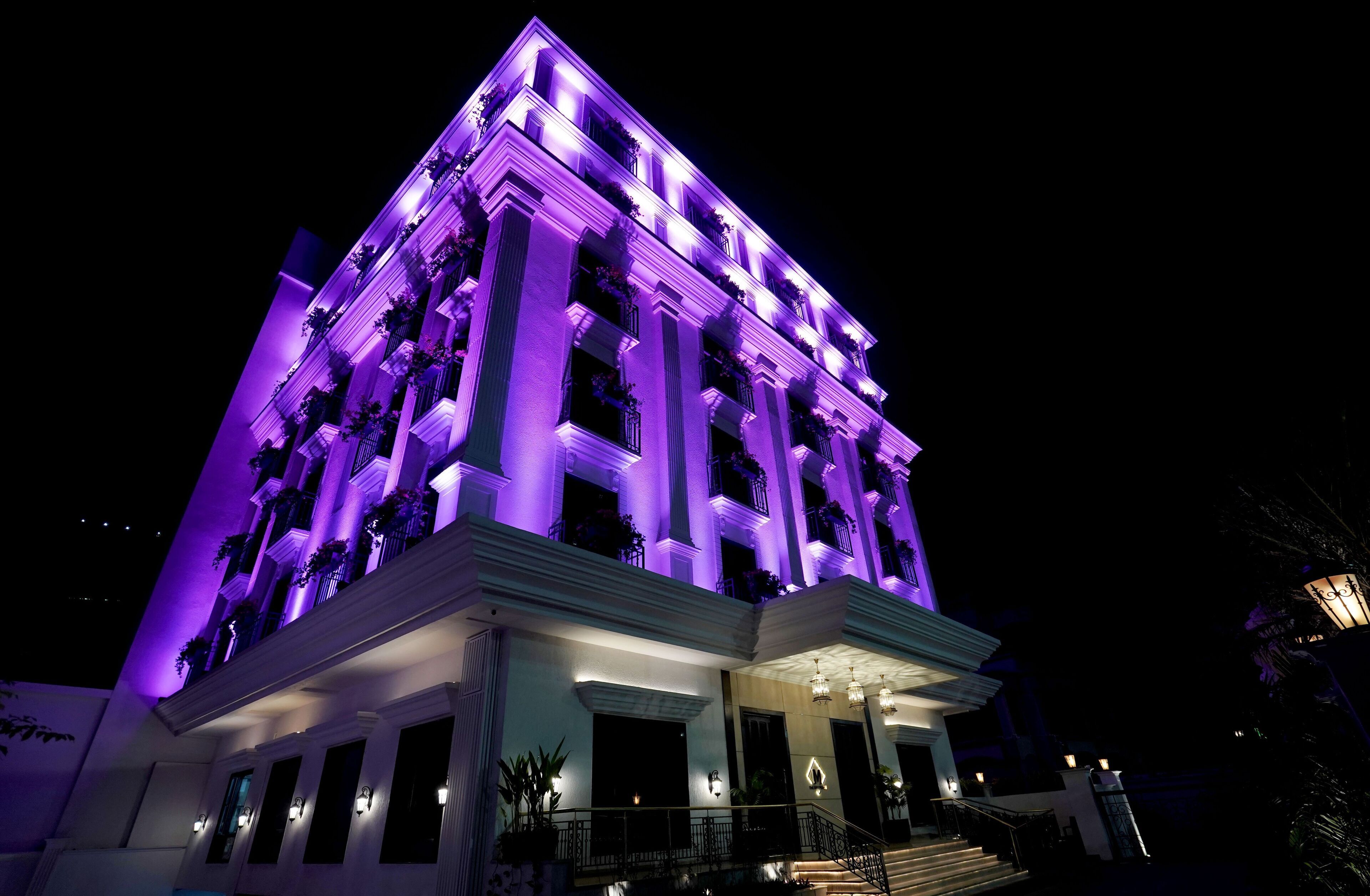 A multi-story building with a symmetrical facade, large windows, and a central entrance with steps.