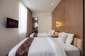 A hotel room with two beds, a TV, and a wooden wardrobe. - Villa Trix Canggu - Elegant 4BR Villa for Families & Friends (Badung)
