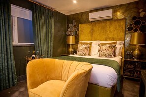 A hotel room with a bed, a chair, an air conditioner, and decorative mirrors. - Funky Monk Restaurant and Rooms (Epping)