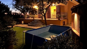 Un edificio residenziale con piscina, scale esterne e un albero.