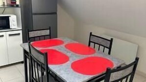 Ein Essbereich mit Tisch und Stühlen, einer Mikrowelle und einem Kühlschrank.