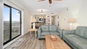 A living room with a sofa, a coffee table, and a ceiling fan. - Two Bedroom Beachfront End Unit Condo with Pool. (Ocean City)