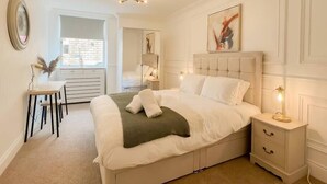 A bedroom with a large bed, bedside tables, a desk, and a wardrobe. - Cozy 1 bed Blythswood Apartment (Glasgow City)