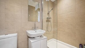 Un baño con lavabo blanco, espejo, ducha y bañera.