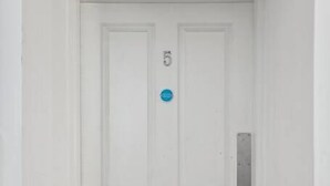 A white door with the number 5 on it, a metal mail slot, and a dark carpeted floor. - (G5) Grand 1 bed Blythswood Apartment (Glasgow City)
