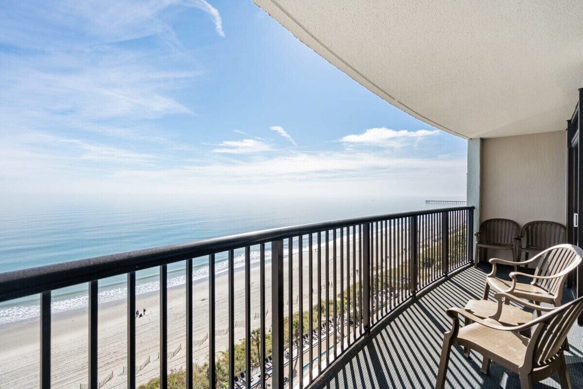 Un balcon avec vue sur la plage et l’océan.