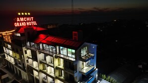 Un hôtel à plusieurs étages, doté d’une piscine sur le toit et d’une enseigne bien visible.
