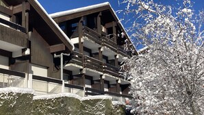 A multi-story building with balconies and a snow-covered tree. - 1 bedroom apartment 27 m2 4 People near the Gondola (Les Contamines-Montjoie)