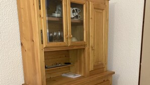 A wooden cabinet with multiple drawers and a glass-fronted shelf. - 1 bedroom apartment 27 m2 4 People near the Gondola (Les Contamines-Montjoie)