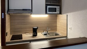 A compact kitchenette with a microwave, coffee maker, and sink. - 1 bedroom apartment 27 m2 4 People near the Gondola (Les Contamines-Montjoie)