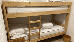 A bunk bed with a wooden frame, white bedding, and a small wooden stool. - 1 bedroom apartment 27 m2 4 People near the Gondola (Les Contamines-Montjoie)