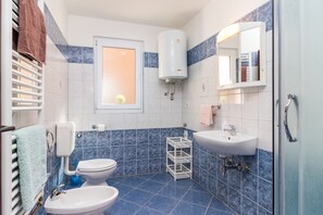 Un baño con inodoro, lavabo y ventana.