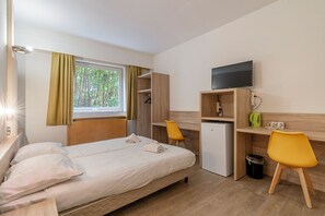 A hotel room with a bed, a desk, a television, and a window with curtains. - Room-sleep & Go Brussels South - Budget (St. Genesius-Rode)