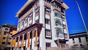 A multi-story building with traditional architectural elements, including ornate balconies and a flat roof. - Tshongdu Boutique (Paro)