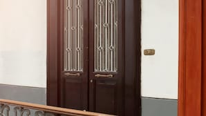 A dark wooden double door with decorative glass panels and a brass handle.