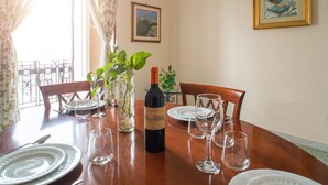 A dining table set with plates, glasses, and a bottle of wine.