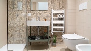 Un baño moderno con cabina de ducha de vidrio, un lavabo blanco, un inodoro blanco y una bañera.
