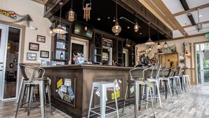 A bar area with a counter, bar stools, and hanging lights. - Modern 3BR Near Disney w Gameroom & Free Waterpark (Davenport)