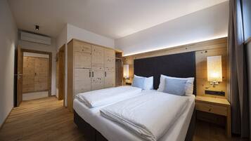 Ein Hotelzimmer mit einem großen Bett, einem Holzschrank, Nachttischlampen und einer Deckenleuchte.