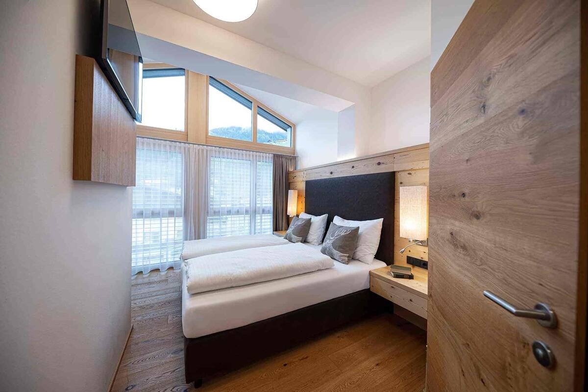 Ein Schlafzimmer mit einem Bett, einem Nachttisch, einer Lampe und einem Holzschrank.