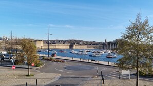 A marina with boats docked, a roundabout, and a historic building in the background. - REF 410 Bel Appartement de 80m² au Centre de Concarneau (Concarneau)