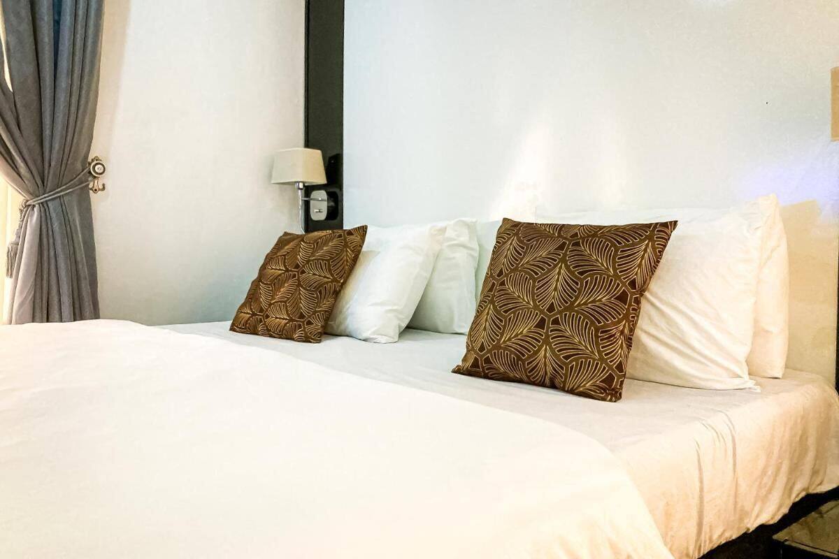 Habitación de hotel con una cama grande, una lámpara de noche y vistas a la ciudad.