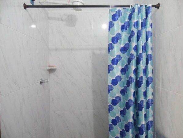 A bathroom with a shower curtain featuring a blue and white pattern, a towel rack, and a wall-mounted towel dispenser. - Piso 1. Hermoso Amanecer Frente al Embalse! (Peñol)