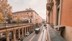 A street with a pedestrian bridge, a bus, and cars.