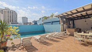 A rooftop pool area with lounge chairs and a covered seating area. - Urban Bliss Flat | Stylish 1-Bed in Best Location (San Juan)