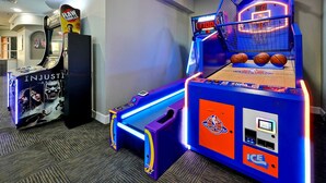 A room with arcade games, including a basketball game and a claw machine. - Mickey s Welcome Inn - Closest Resort to Disney (Kissimmee)