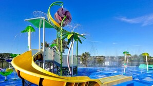 A water park with a yellow slide, water jets, and palm trees. - Mickey s Welcome Inn - Closest Resort to Disney (Kissimmee)