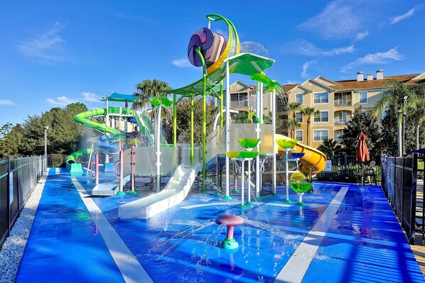 Un parc aquatique doté de nombreux toboggans et d’attractions aquatiques, entouré d’une clôture et de palmiers.