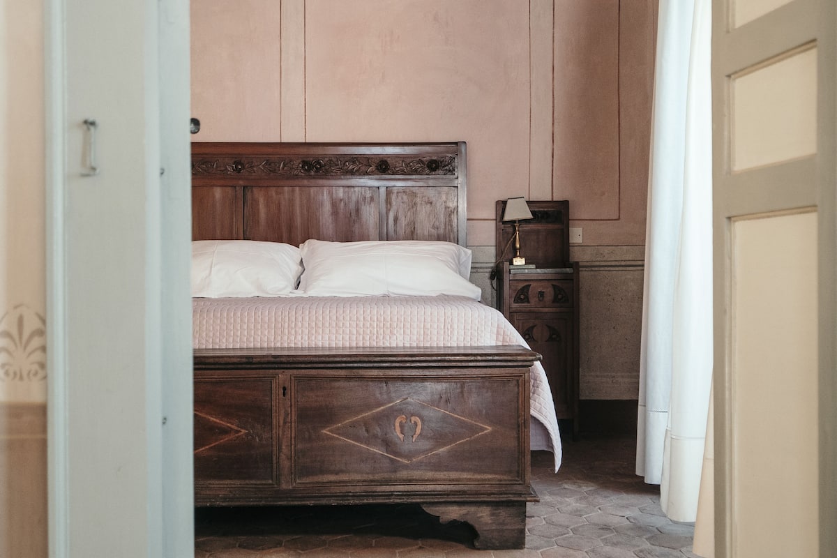 Une chambre à coucher avec un lit en bois, une table de chevet et une porte.