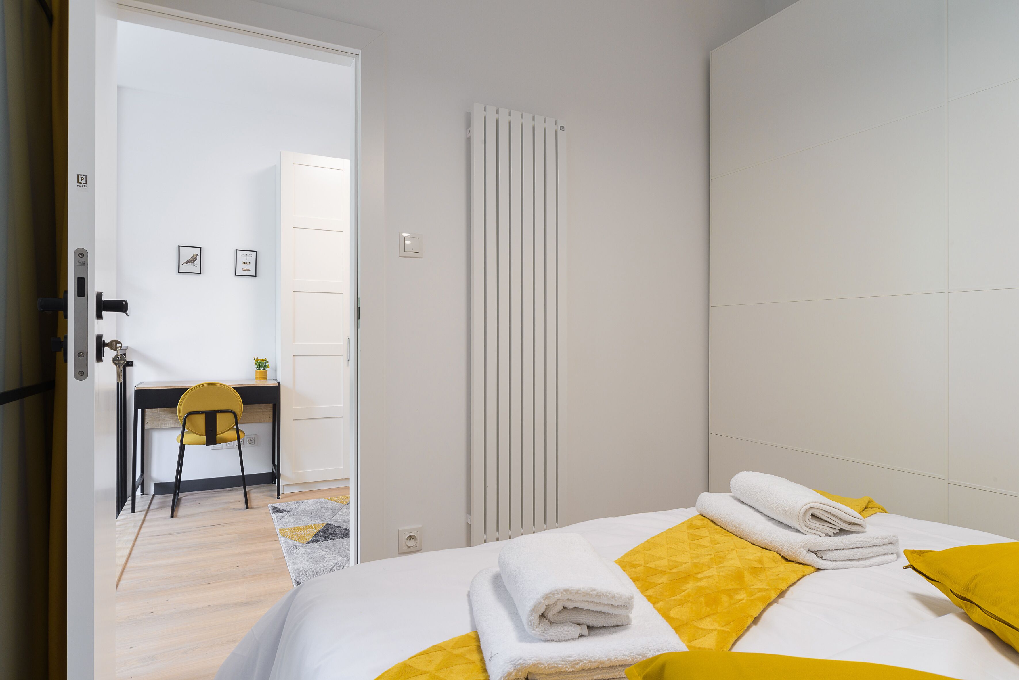 Una habitación de hotel con una cama, un escritorio y una silla.
