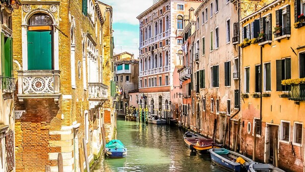 A narrow canal with boats docked on both sides, surrounded by historic buildings with varied architectural styles. - 2 bedroom apartment in venice (Venezia)