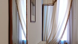 A room with a wooden table, a chair, a radiator, and a mirror. - 2 bedroom apartment in venice (Venezia)