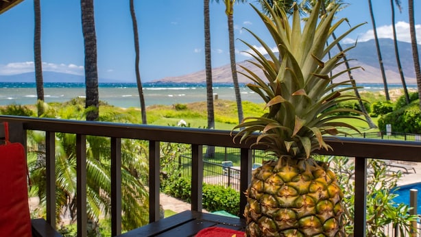 Un balcón con vista a una playa y el océano, con una piña.