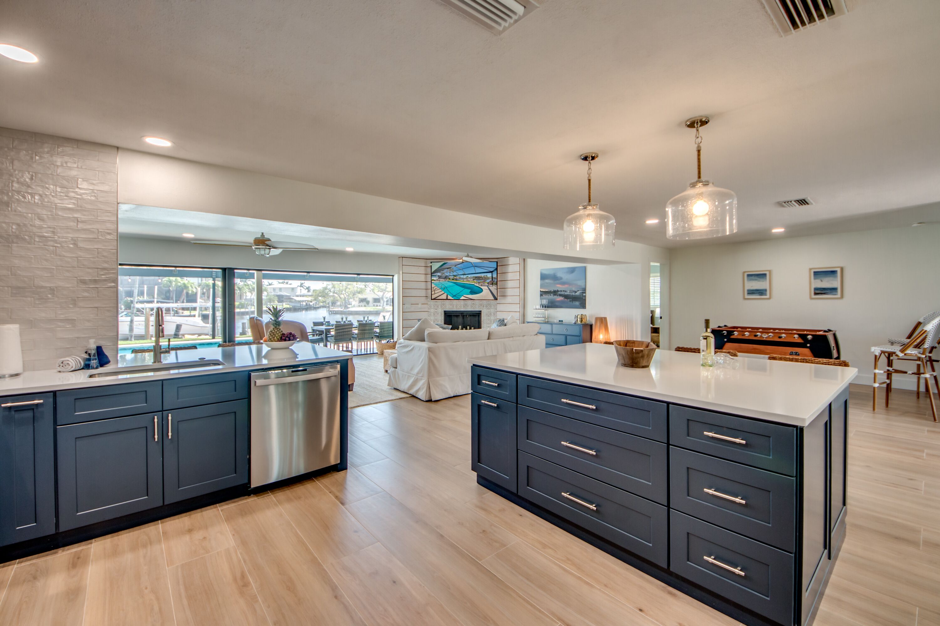 A modern kitchen with dark cabinetry, a dishwasher, and a large island.